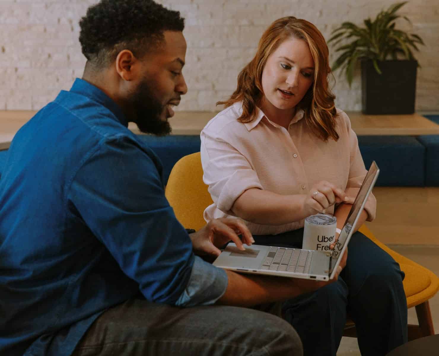 two people discussing something on laptop