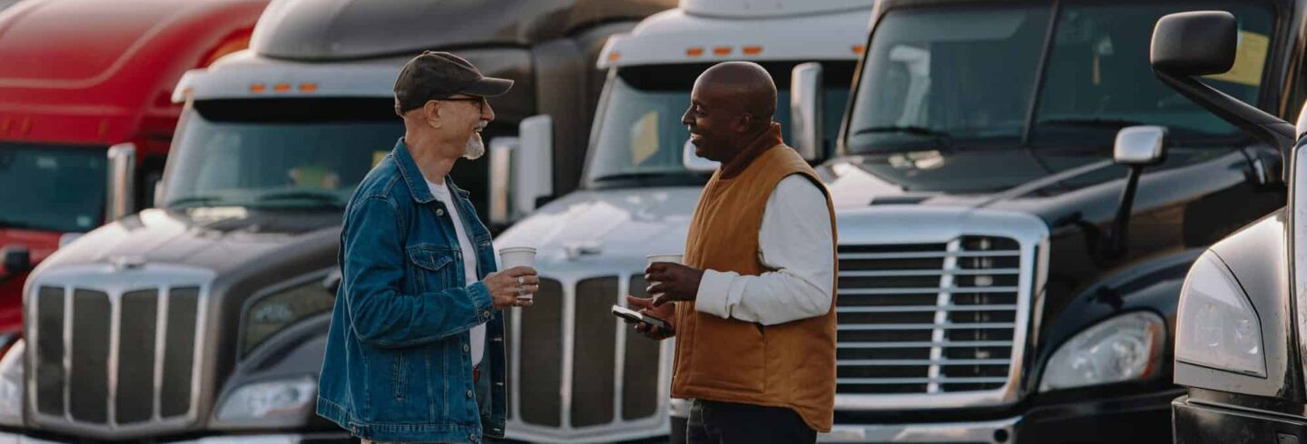 two men discussing something in front of truck