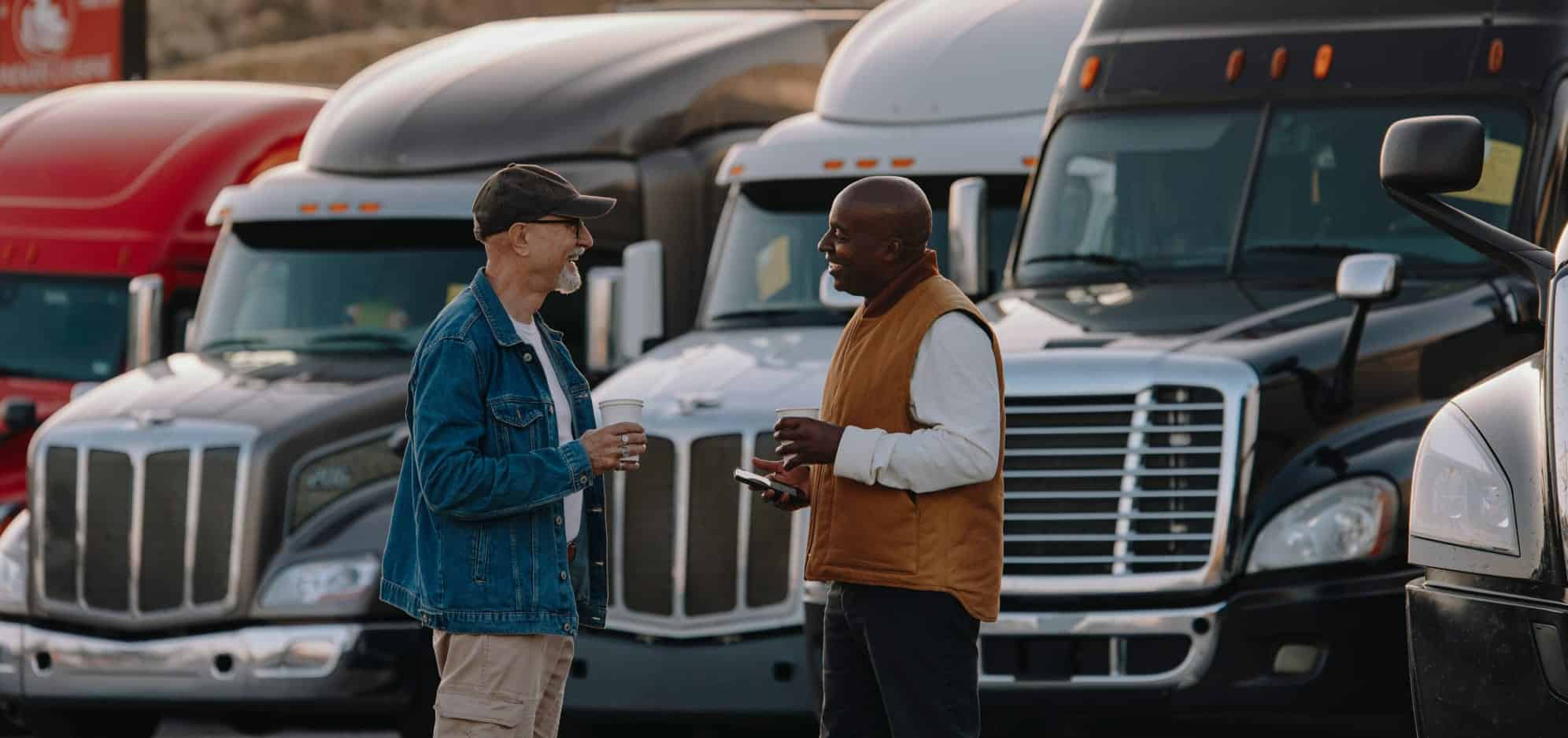 two men discussing something in front of truck